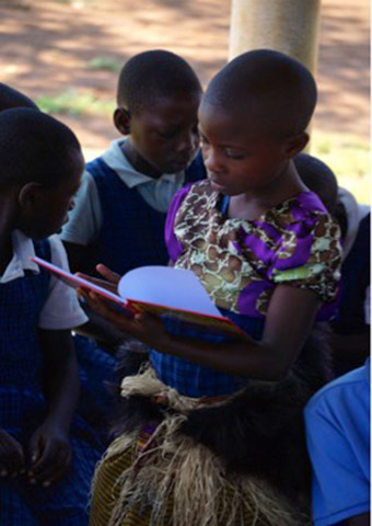 Joanne, one of the pupils at NCLC reading Tales of Nabugabo